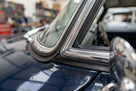 Chrome filler strip fitted to the windscreen surround of a dark blue classic car