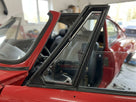 Black quarter light frame fitted to the door of a red classic car