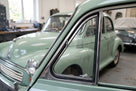 Quarterlight seal wraps the chrome window frame of a pale green classic car