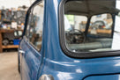 Black rubber seal fitted around the rear quarterlight window of a blue classic Mini