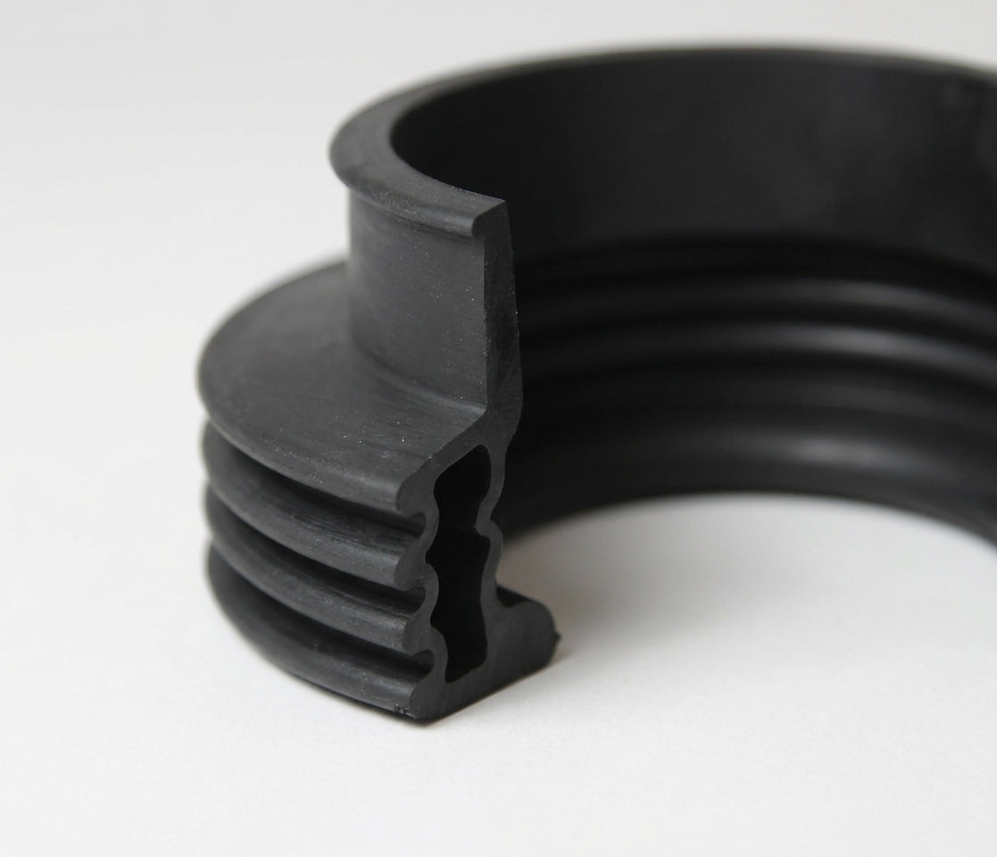Black ribbed rubber gaiter with a bellows profile, close-up studio shot