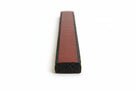 Flat black sponge strip with maroon release liner along the back, studio shot showing cut end