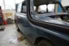 Black sponge strip fitted along the door aperture edge of a blue classic car body