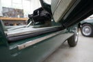 Black sponge strip fitted along a sill edge beneath an open door of a green classic car