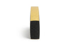 Front-on view of a black sponge strip with tan adhesive backing, showing porous cut face