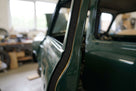 Black sponge strip fitted along a door pillar of a green classic car body