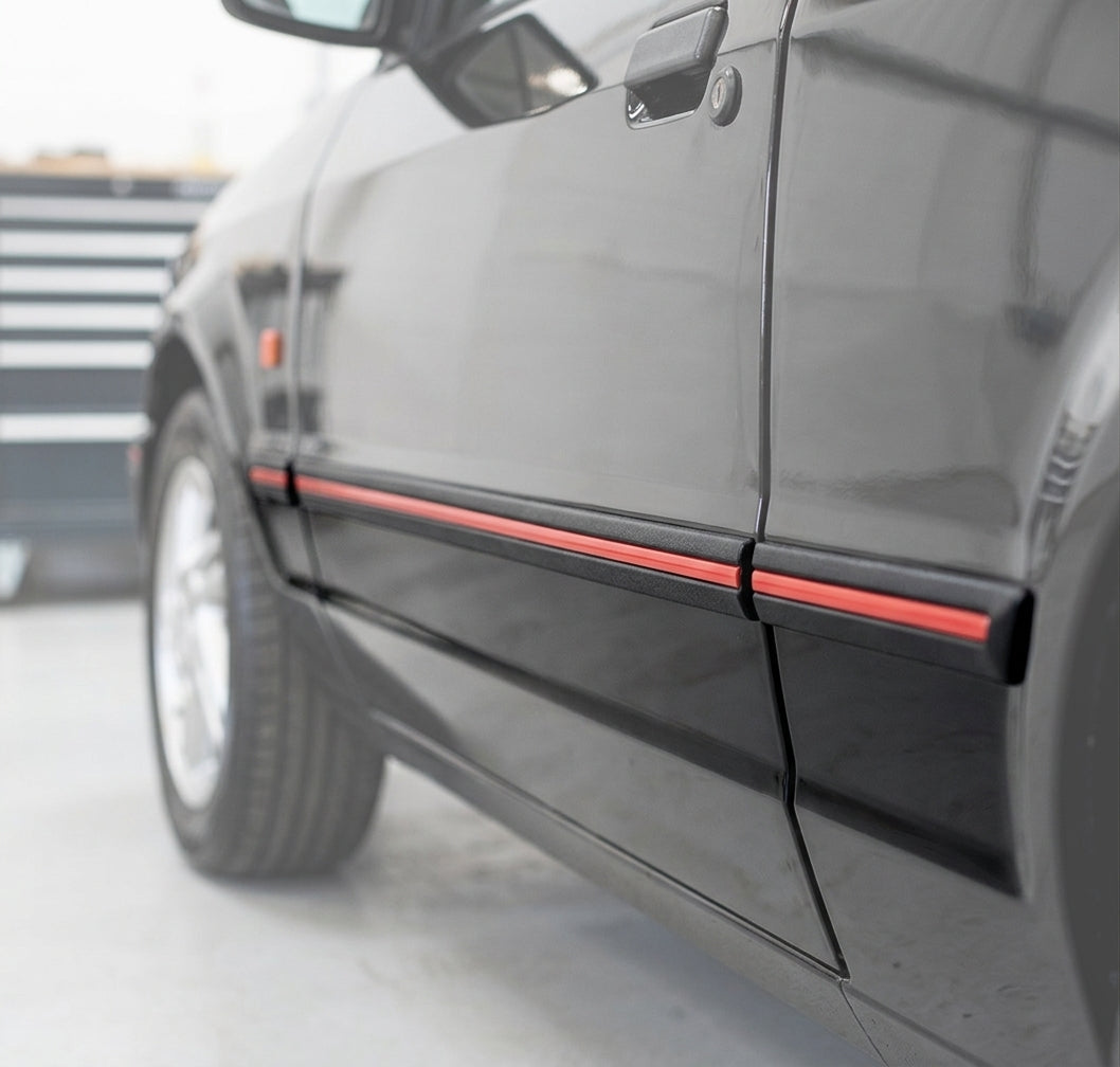 Black door moulding with red insert fitted along a black Escort XR3i's door