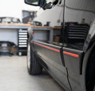 Black door moulding with red insert fitted low along a black Escort's door