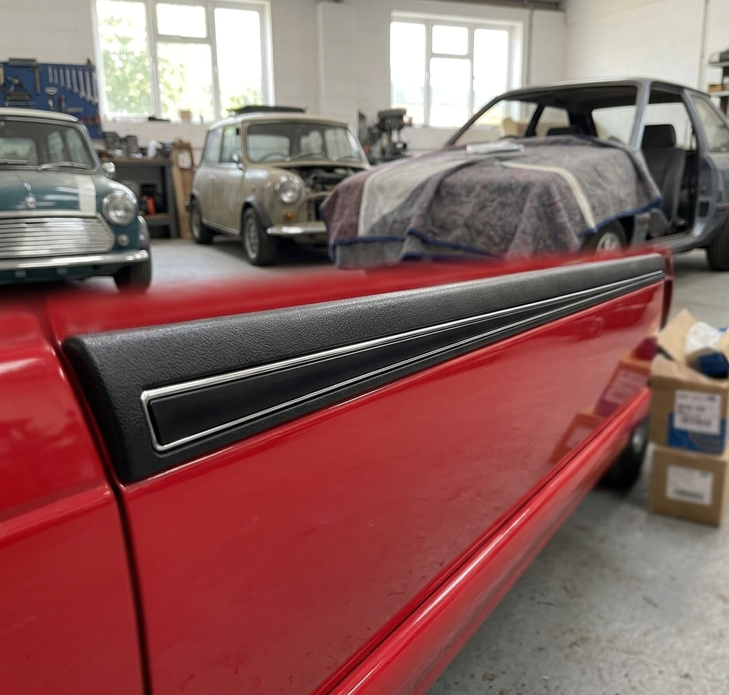 Black door moulding with chrome strip fitted along a red car's door edge