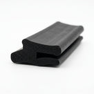 Black rubber boot seal, coiled length showing twin-bulb profile, studio shot