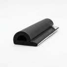 Black D-shaped sponge section with a flat mounting flange and white adhesive tape, cut end