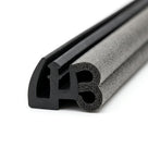 Coiled length of dual-material door seal, smooth black leg beside a grey sponge figure-of-eight bulb.