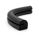 Curved length of black sponge rubber with a notched profile, cut end showing porous texture