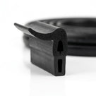 Coiled black dual-hardness hood seal with curved sealing lip, studio shot