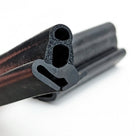 Close-up cut end of black door seal showing two hollow bubble chambers