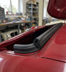 Black boot lid seal fitted along the edge of a red Triumph's boot