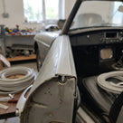 Grey edge trim fitted to a car door edge, with coiled cable in the background