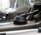 Black rubber gaiter fitted over a boot release lever, angled workshop view