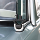 Black rubber seal fitted to a chrome window frame corner on a classic car