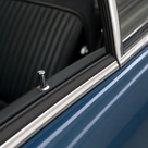 Black PVC filler strip fitted inside chrome window trim on a blue classic car