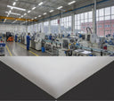 Split composite: factory floor with staff at machines above, white sheet corner on dark below