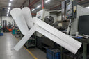 Bundle of white PTFE rods angled across a workshop in front of a CNC lathe