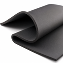 Black neoprene sheet curled back on white, the cut edge showing its fine closed-cell structure