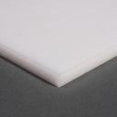 Corner of a thick white polypropylene sheet on a grey background, crisp sawn edge to the front