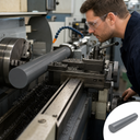 Machinist watching a grey PVC bar turn between lathe chuck and toolpost, inset of the plain grey rod