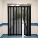 Black mesh fly screen strip curtain on a stainless hook-on rail in a tiled kitchen doorway, one strip pushed aside