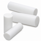 Four short white PTFE billets in different diameters leaning together on a white background