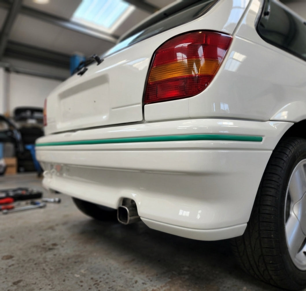 Green trim strip fitted along a white Fiesta RS Turbo's rear bumper