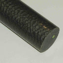 Close-up of a black-grey Nylatron rod with pitted crazed skin and a sawn end face at the right