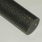 Close-up of a black-grey Nylatron rod with pitted crazed skin and a sawn end face at the right