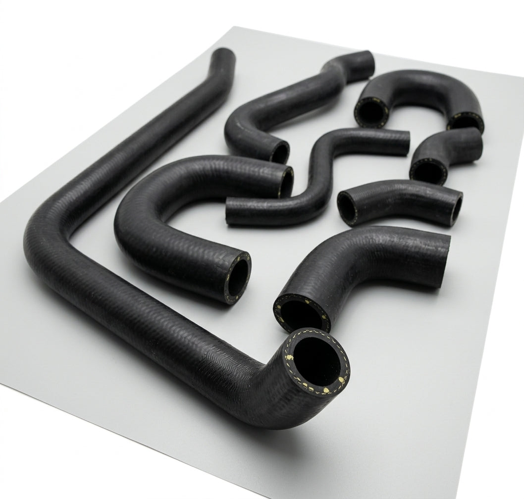 Full set of black moulded coolant hoses laid out for a Triumph Stag hose kit