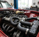 Black coolant hoses fitted throughout the engine bay of a red Triumph Stag