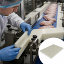 Operator in a hairnet bolting a cream nylon side guide to a poultry line, inset of a thin pale sheet