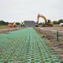 Black hexagonal polymer mesh flooring for grass protection and ground reinforcement with slip-resistant surface