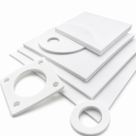White PTFE sheets on white with cut flange gaskets and rings laid in front of them