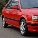 Black door mouldings fitted along a red Escort XR3i's sills and doors