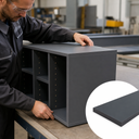 Maker fitting the top onto a dark grey shelved cabinet in a workshop, inset dark grey sheet