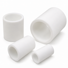 Four white PTFE tube sections of differing diameters and lengths grouped on a white background