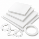 Four white PTFE sheets stacked on white with square and ring gaskets cut from them in front