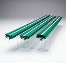 Three green moulding pieces with a white centre stripe displayed on a stand