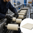 Worker fitting cream nylon rollers onto a conveyor line, inset studio shot of a cream sheet corner