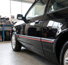 Black door mouldings with red insert stripe fitted along a black Escort's sill