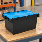 Illustrative warehouse use of 80L polypropylene hinged-lid crate with black base and blue lids