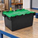 Illustrative warehouse use of 80L polypropylene hinged-lid crate with black base and green lids