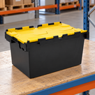 Illustrative warehouse use of 80L polypropylene hinged-lid crate with black base and yellow lids