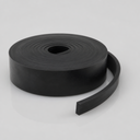 Chunky roll of black rubber strip lying flat, free end stood on edge to reveal its deep square section